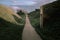 Idyllic pathway winding through a picturesque landscape of rolling grassy hills