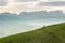 Idyllic and peaceful mountain landscape with a wooden fence on a grassy hillside and a great view of the Swiss Alps behind