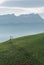 Idyllic and peaceful mountain landscape with a wooden fence on a grassy hillside and a great view of the Swiss Alps behind