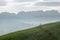 Idyllic and peaceful mountain landscape with a wooden fence on a grassy hillside and a great view of the Swiss Alps behind