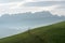 Idyllic and peaceful mountain landscape with a wooden fence on a grassy hillside and a great view of the Swiss Alps behind