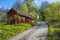 Idyllic red barn at dirt road at springtime