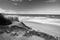 Idyllic sandy beach in sunny sky by atlantic ocean in bidart in black and white, basque country, france