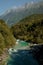 Idyllic scene of the Soca river winding through a dense, verdant forest in Slovenia.