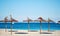 Idyllic scenery, concept of summer holidays, straw parasols in a row on the coast of blue Mediterranean Sea