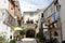 Idyllic scenery of old part of Mediterranean town with narrow street surrounded with old houses with wooden window blinds and