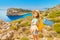 Idyllic sea resort landscapes of Greece. Student girl with backpack travelling near blue bay