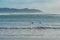 Idyllic seascape. Quiet ocean, mountains, and surfers silhouettes at Morro Bay, CA