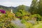 Idyllic spa garden Schliersee with view to St. Sixtus church, colorful flowerbed