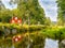 Idyllic Swedish landscape near a canal with a red house in the background.BjurbÃ¤cken / VÃ¤rmland