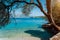 Idyllic tranquil turquoise bay view framed with old olive tree. Luxury yacht in the distance. Summer beach vacation relaxation