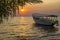 Idyllic view on boat floating on waves against of sunset