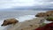 Idyllic view of cliffs amidst beautiful seascape with cloudy sky in the background