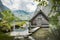 Idyllic view of traditional old wooden boat house at scenic Lake Obersee