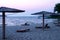 Iew of sandy beach with bamboo umbrellas and sun beds at sunrise