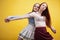 ifestyle people concept: two pretty young school teenage girls having fun happy smiling on yellow background