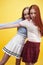 ifestyle people concept: two pretty young school teenage girls having fun happy smiling on yellow background