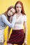 ifestyle people concept: two pretty young school teenage girls having fun happy smiling on yellow background