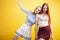 ifestyle people concept: two pretty young school teenage girls having fun happy smiling on yellow background