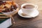 Iftar concept, white Cup of tea, plate of dried fruit, Koran with prayer beads on brown wooden table in sun