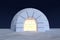 Igloo icehouse with warm light inside under sky with night stars