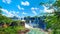 Iguazu waterfalls in Argentina, powerful water streams creating mist over Iguazu river. Panoramic image of waterfalls and sub-