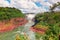 Iguazu waterfalls in Argentina. Tourist motor boat going towards powerful water cascade creating mist over Iguazu river. Overcast