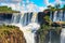 Iguazu waterfalls in Argentina, view from Devil`s Mouth. Panoramic view of many majestic powerful water cascades creating mist