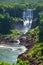 Iguazu waterfalls in Argentina, view from Devil`s Mouth. Panoramic view of many majestic powerful water cascades creating mist.