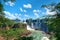 Iguazu waterfalls in Argentina, view from Devil`s Mouth. Panoramic view of many majestic powerful water cascades creating mist