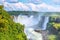 Iguazu waterfalls in Argentina, view from Devil`s Mouth. Panoramic view of many majestic powerful water cascades with mist.