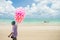 Ilha de Itamaraca, Brazil - Circa December 2018: Man selling cotton candy at the beach, jangada traditional boat in the ocean in