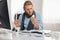 Ill bearded male office worker in blue shirt and scarf with spectacles concentrated on reading prescription of pills