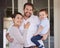 Ill carry him to greatness. Shot of a family standing together on the porch at home.