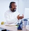 Ill explain it to you in detail. a mature call centre agent working on a laptop in an office.