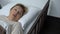 Ill pensioner woman lying in sickbed and closing face with trembling hand, fear