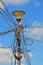 Illegal industrial powerful electric cable bulk with insulating tape fixing on metal pylon on blue sky with clouds, power outage,