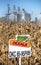 Illinois, USA, October 2020 - Dekalb chemical sign in midwest corn field, with dried brown feed corn on stalks, grain silos