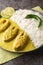 Illish or Hilsa fish cooking with mustard seed sauce served with white rice closeup on the plate. Vertical