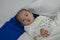 Illness asian baby boy lying down on sickbed and looking at camera