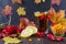 Illness concept: Cup of tea with autumn berries sea buckthorn, viburnum, rose hip, rowan and fall leaves. Drink with vitamin c