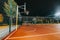 Illuminated basketball playground with red pavement, modern new basketball net