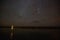 illuminated building reflected in water and majestic starry sky