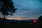 Illuminated camping tent at twilight under sunset sky on the mountain peak. Thai-Laos border. Phu Suan Sai National Park, Na Haeo