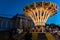 The illuminated carousel spins in the night. 2020 summer in the city folk festival in Munich