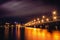 Illuminated Chernavsky bridge at night, view to right bank or downtown of Voronezh city, dramatic cityscape with reflection