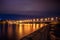 Illuminated Chernavsky bridge at night, view to right bank or downtown of Voronezh city, dramatic cityscape with reflection