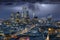 The illuminated City of London with a thunderstorm and dark clouds