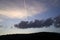 Illuminated Clouds at Sunset with Vapor Trail and Hills