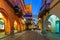 Illuminated cobblestone street in old town of Alba.